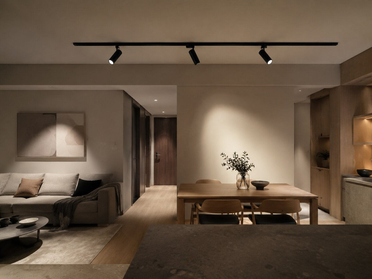Illustrative dining and living space with directional track lights and recessed ceiling lights.